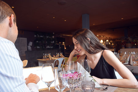 couple looking at the letter in an elegant restaurant to dine calmlyの写真素材