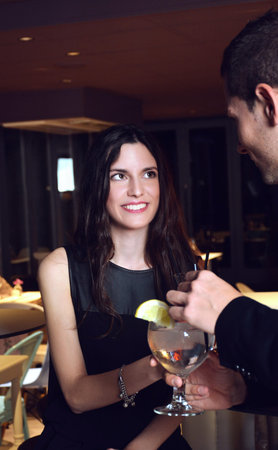 couple in love drinking cocktails in an elegant bar at night