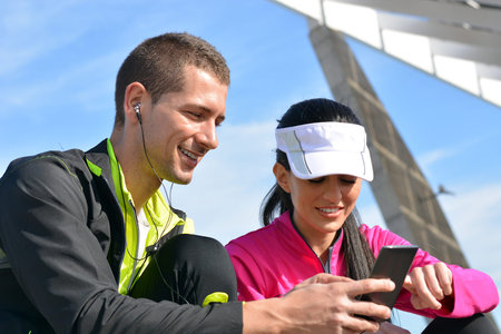 couple of runners looking an application of Athletics while rest of run