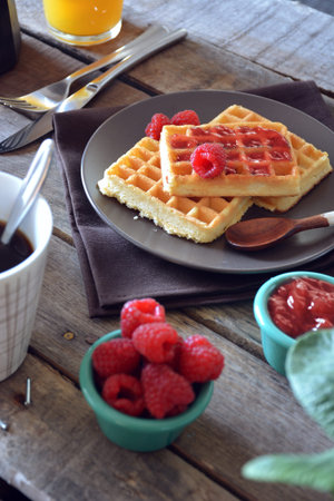plate of waffles with raspberry marmalade, orange juice and coffeeの写真素材