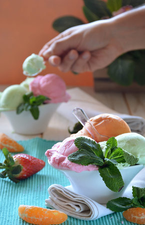 ice cream of various flavors, accompanied by Mint, Tangerine and strawberries