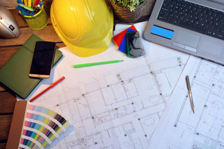 OFFICE OF ARCHITECTURE WITH DRAWINGS, COMPUTER AND PERSON WORKING