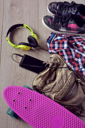 skateboard with bag, sneakers and mobile phoneの写真素材