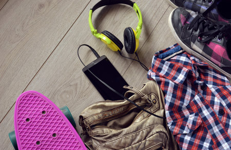 skateboard with bag, sneakers and mobile phone