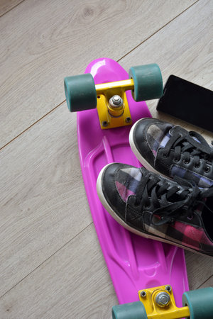 skateboard with bag, sneakers and mobile phone