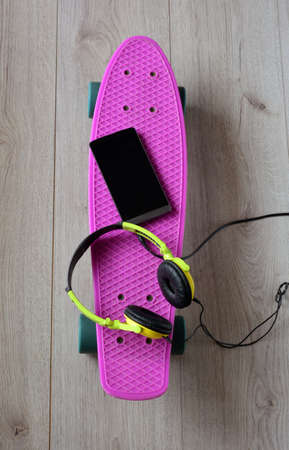 skateboard with bag, sneakers and mobile phoneの写真素材