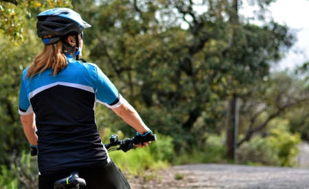 happy woman riding mountain bike through the countrysideの写真素材