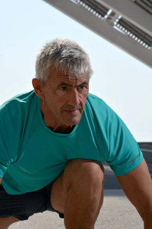 Older man practicing stretching on the street.の写真素材