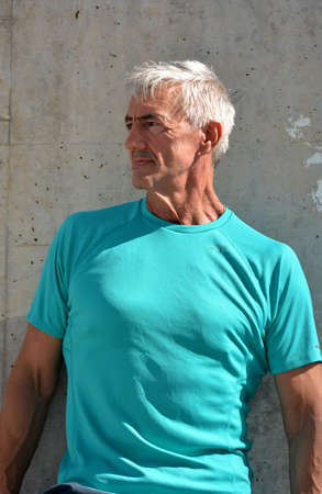 Older man practicing stretching on the street.の写真素材