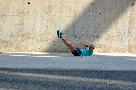 Older man practicing stretching on the street.の写真素材