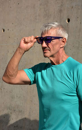 Older man practicing stretching on the street.の写真素材