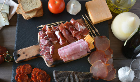 VARIOUS TYPES OF SPANISH SAUSAGES ACCOMPANIED BY WINE AND TOASTED BREAD