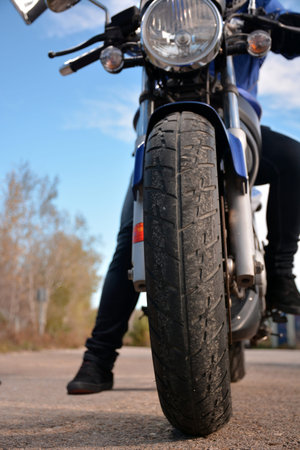 biker with helmet blue going by a road alone