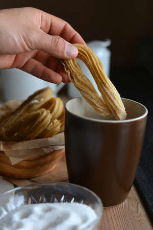 Churros accompanied of a cup of chocolate hot and sugarの写真素材