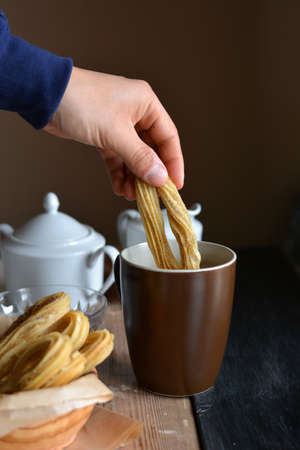Churros accompanied of a cup of chocolate hot and sugarの写真素材