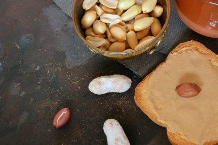 Homemade cream of peanut on table of stone, accompanied by fried peanuts