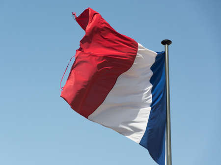 French flag moving with the wind on a summer afternoonの写真素材
