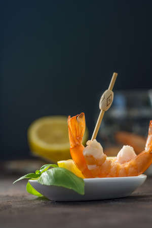 Appetizer of fresh prawns accompanied by lemon and put in a glass dishの写真素材