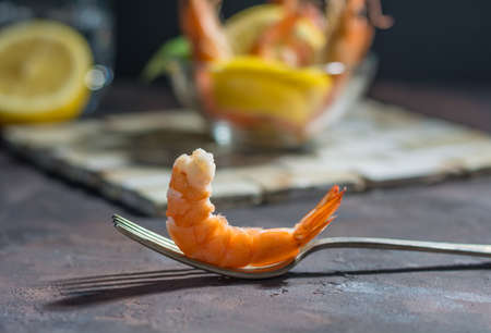 Appetizer of fresh prawns accompanied by lemon and put in a glass dishの写真素材