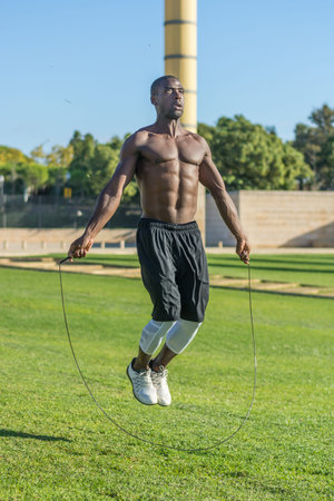 African American man training in a park, jumping ropeの写真素材
