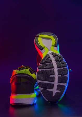 sports footwear on a black background and with splashes of waterの写真素材