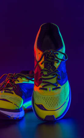 sports footwear on a black background and with splashes of waterの写真素材