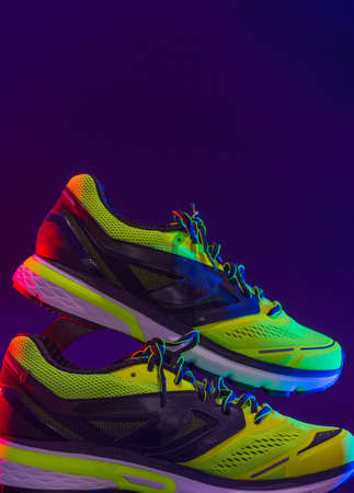 sports footwear on a black background and with splashes of waterの写真素材