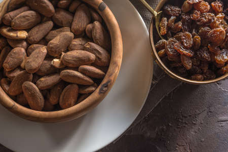 Almond with raisins in a dish of wood with oatmealの写真素材