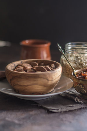 Almond with raisins in a dish of wood with oatmealの写真素材
