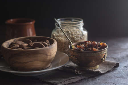 Almond with raisins in a dish of wood with oatmealの写真素材