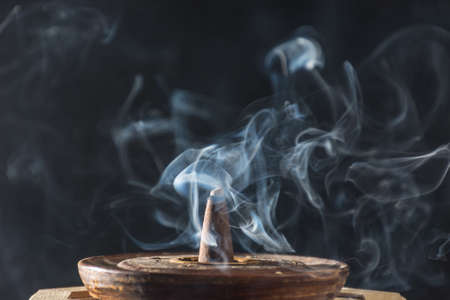 photograph of smoke caused by various incenses on black backgroundの写真素材