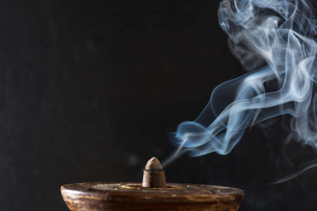 photograph of smoke caused by various incenses on black backgroundの写真素材