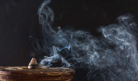 photograph of smoke caused by various incenses on black backgroundの写真素材