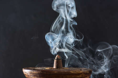 photograph of smoke caused by various incenses on black backgroundの写真素材