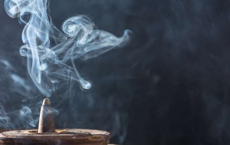 photograph of smoke caused by various incenses on black backgroundの写真素材