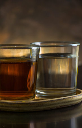 two different glasses of tequila, one is stale and the other white. typical Mexican drink