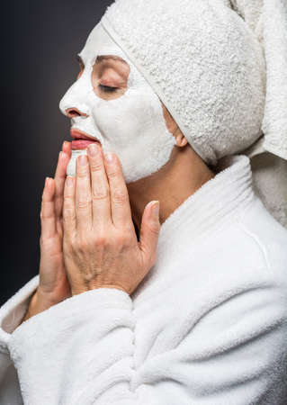 mature woman is white clay on his face maskの写真素材