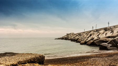 Sunset on a beach in Blanes, where you can see the wall breakwater of the portの写真素材