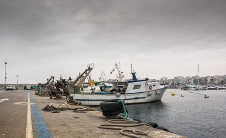 Photograph of a fishing port on a cloudy day. The port is located in Blanes, Spainの写真素材
