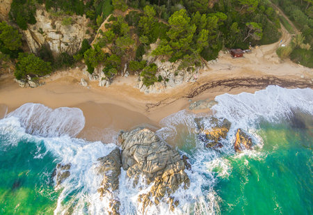 Aerial views of the Costa Brava in Catalonia. Beach full of rocks and waves in Spain