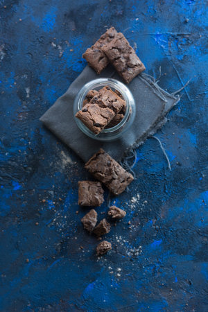 fresh homemade chocolate cookies on a baking tray accompanied by a cup of milk