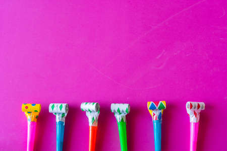 birthday celebration with paper hats, confetti, candles and party blowersの写真素材
