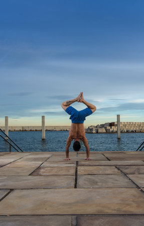 Man performing advanced yoga exercises and stretching to keep the body healthy