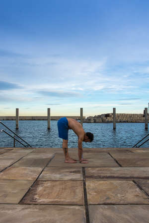 Man performing advanced yoga exercises and stretching to keep the body healthyの写真素材