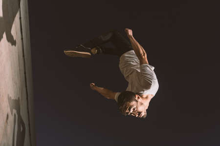 young sportsman practicing parkour, acrobatics and deadly jumps in the streets of the cityの写真素材