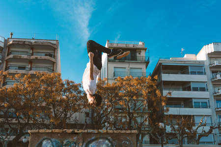 young sportsman practicing parkour, acrobatics and deadly jumps in the streets of the cityの写真素材