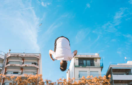 young sportsman practicing parkour, acrobatics and deadly jumps in the streets of the cityの写真素材