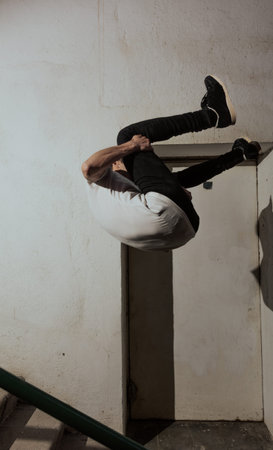 young sportsman practicing parkour, acrobatics and deadly jumps in the streets of the city