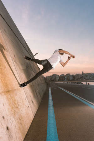 young sportsman practicing parkour, acrobatics and deadly jumps in the streets of the cityの写真素材