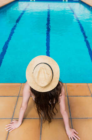 16 year old girl sunbathing peacefully in the pool of her house one summer afternoonの写真素材